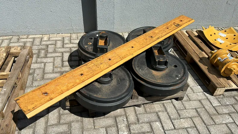 Rodas guia de esteira com uma lâmina amarela por cima